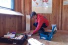 Ein junger Mann arbeitet am Boden eines Holzzimmers