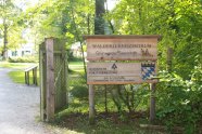Eingangsschild des Walderlebniszentrum Grünwald mit Logo und Wappen