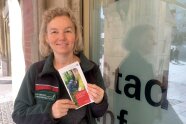 Frau Hagen, Leiterin des Walderlebniszentrum Grünwald, hält einen Flyer hoch 