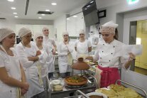 mehrere Frauen stehen um einen Servierwagen herum