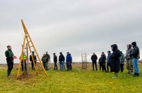 mehrere Personen stehen auf einer Wiese