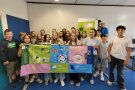 Schülerinnen und Schüler stehen mit Plakaten in einer Gruppe zusammen