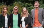 3 Frauen und ein Mann stehend